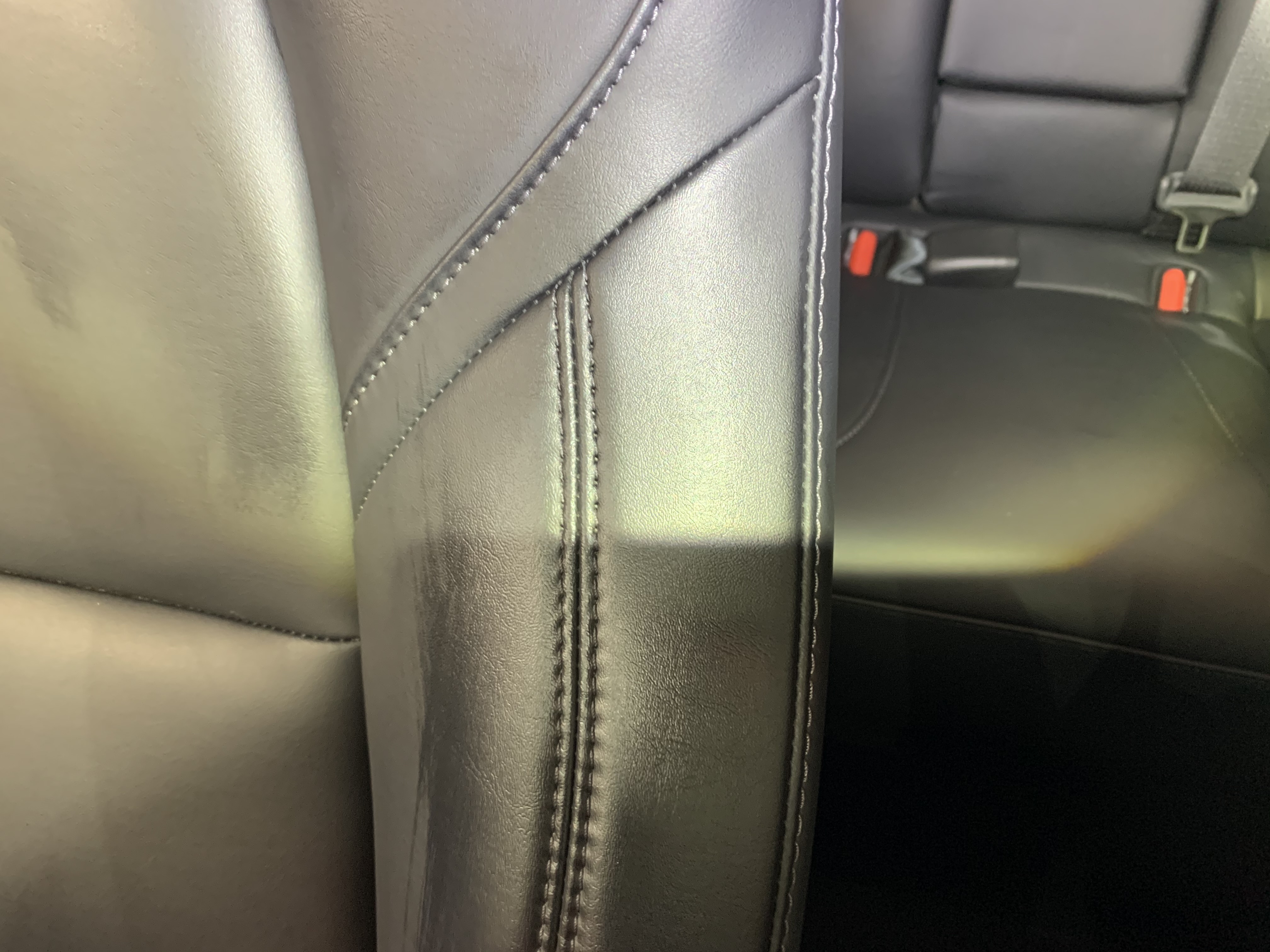 Dark leather seat after PreWow — stain completely removed