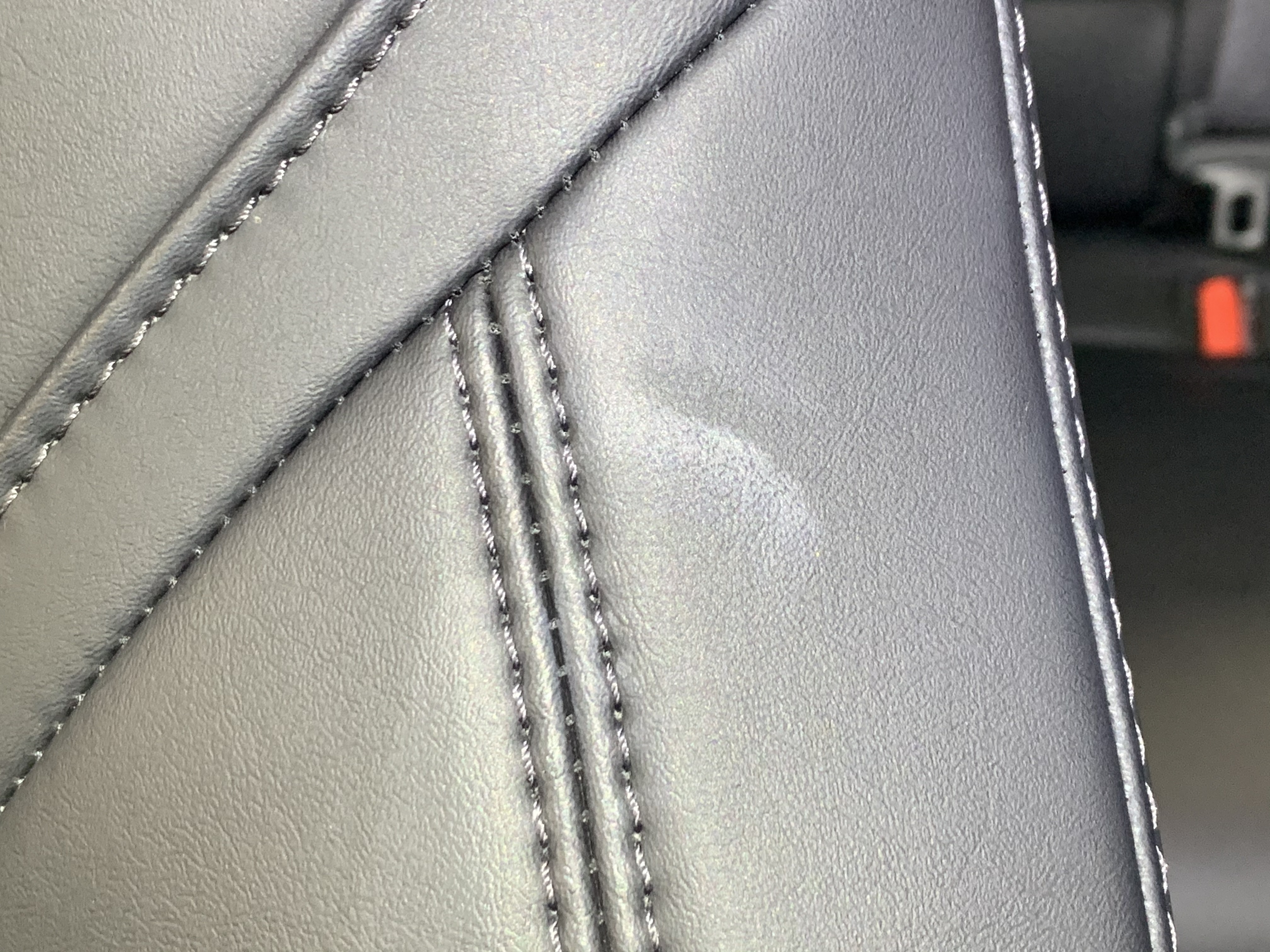 Sunscreen stain on dark leather seat — before PreWow